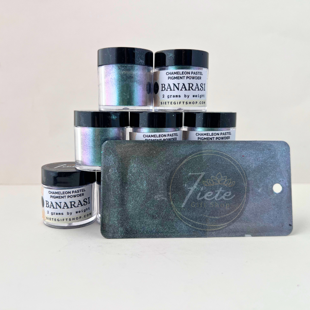 Banarasi chameleon pastel pigment powder jars from Siete Gift Shop showing a soft teal, lavender, and blue color-shifting shimmer with a finished sample swatch in front.