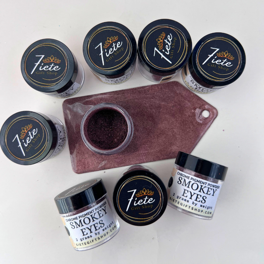 Smokey Eyes chrome pigment powder in 2 gram jars displayed with a deep smoky purple-brown shimmer swatch from Siete Gift Shop.