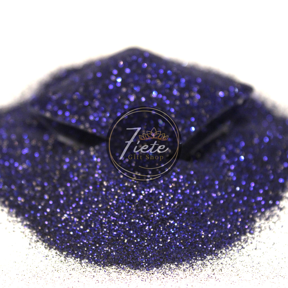 A pile of fine-cut navy blue glitter overflowing from a small clear container and the 'Siete Gift Shop' logo displayed prominently.