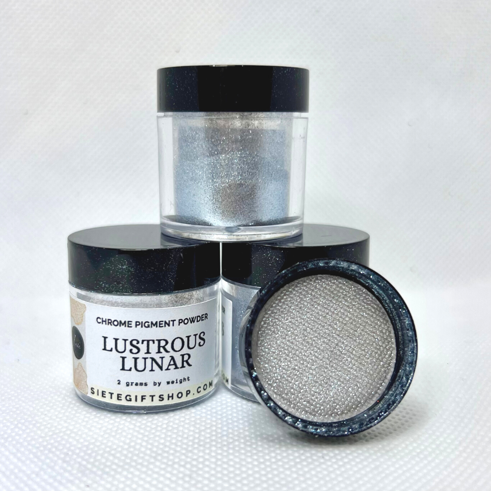Three clear containers with black lids, each filled with 2 grams of silver pigments. One lids is showing the inside of the lid to display the shiny silver powders.