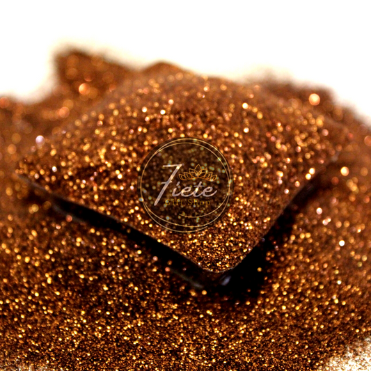 A heap of sparkling, extra-fine metallic brown glitter with a rich, coppery tone similar to an old penny, showcased on a subtle gradient background with a logo of "Siete Gift Shop" in the center.