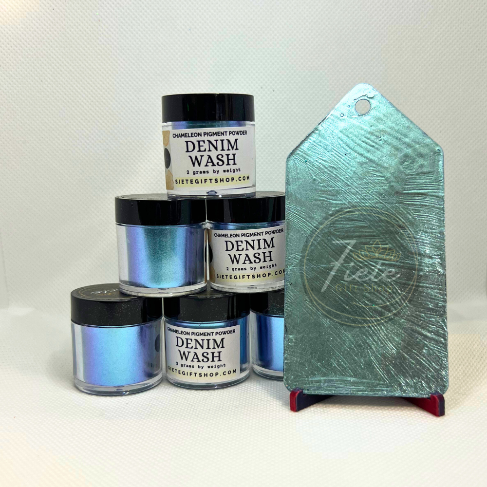  It features several jars labeled "Denim Wash – Chameleon Pigment Powder" from Siete Gift Shop, stacked together. To the right, there's a finished epoxy swatch or display tag showing the pigment’s final look—an iridescent, chameleon shift with cool tones of blue, teal, and a hint of purple depending on the angle.