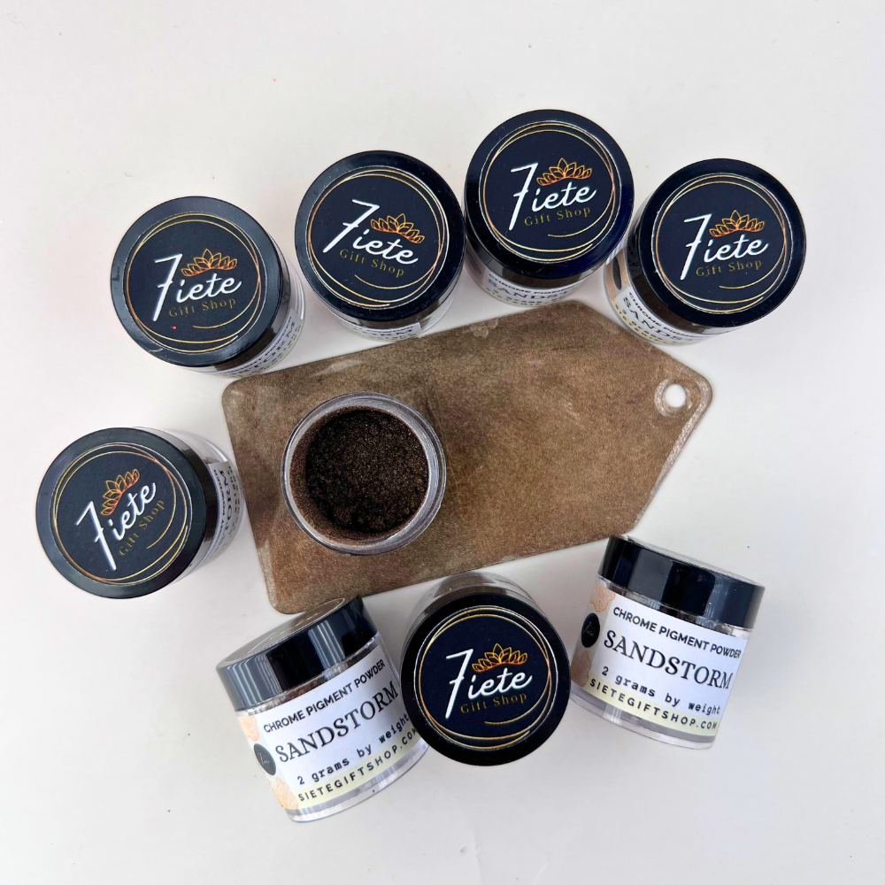 Jars of Sandstorm chrome pigment powder from Siete Gift Shop displayed beside a brown metallic pigment swatch sample.