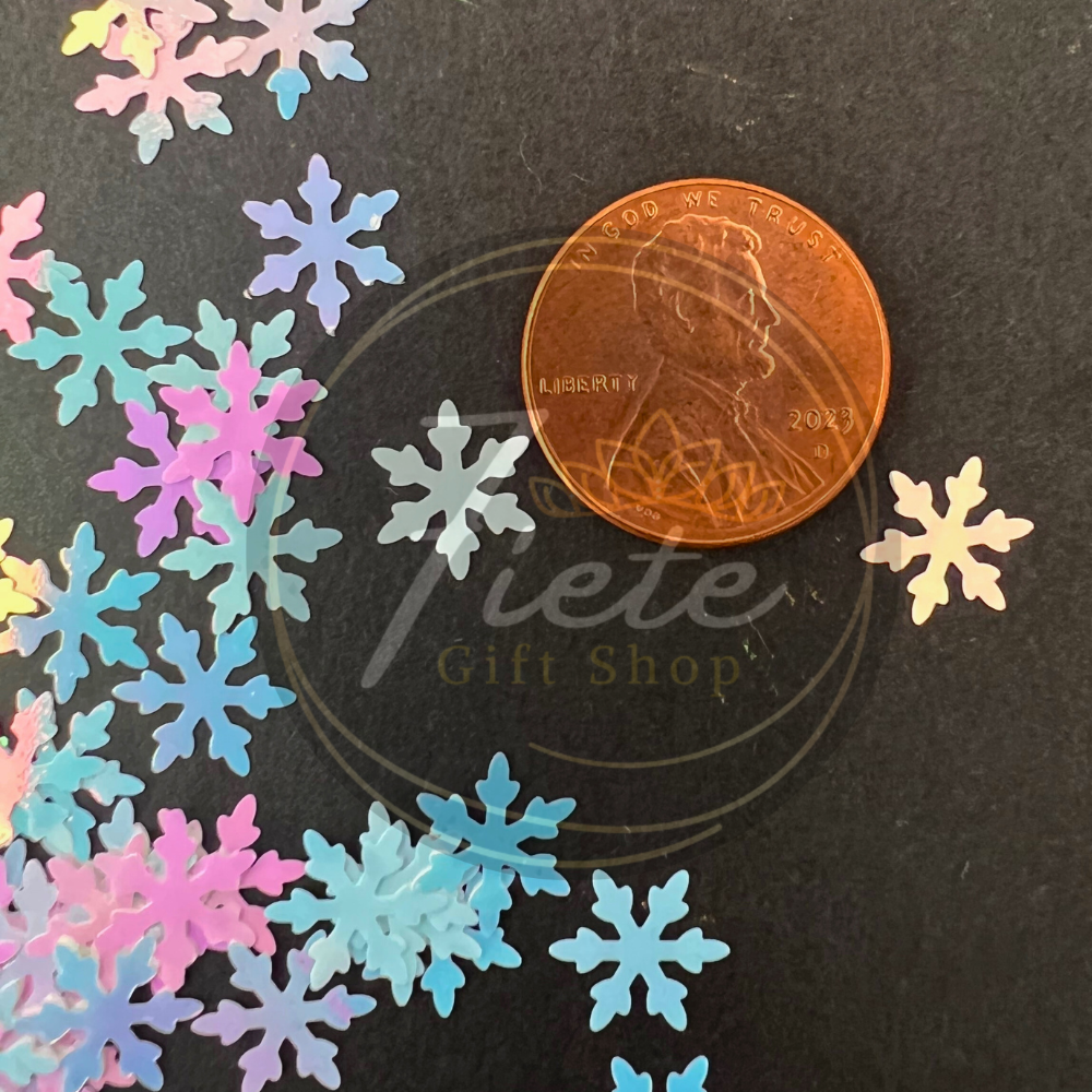 Colorful snowflake decorations with a penny for scale on a black background, featuring 'Tete Gift Shop' logo.