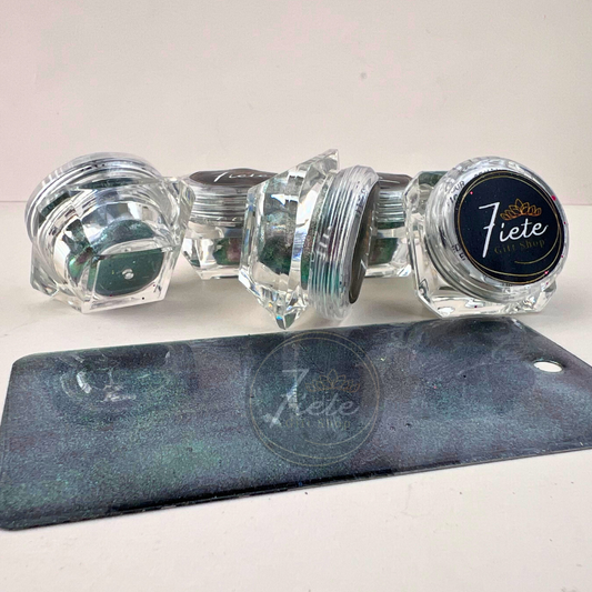 Stacked jars of Georgette chameleon pastel pigment powder from Siete Gift Shop with a green and teal color-shifting sample swatch in front.
