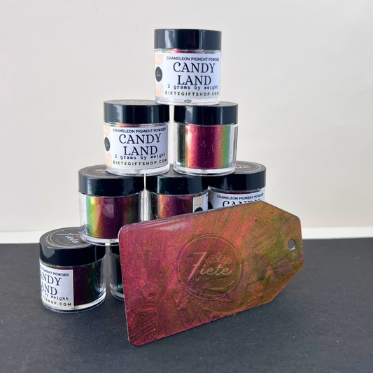 Stack of Siete Gift Shop ‘Candy Land’ chameleon pigment powder jars with a sample swatch tag showing a red-to-gold-to-green color shift.