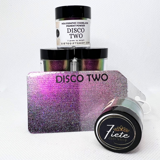 The words "DISCO TWO HOLO CHAMELEON" in bold black letters, and open container of the pigments a metal gift tag displaying when used on light and dark background showcasing the holographic affect. This view shows off dark pink/dark purple colors.